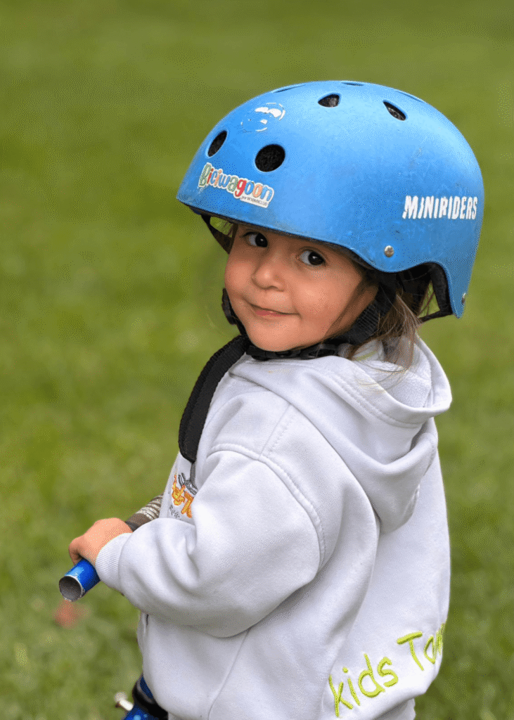 Niña explorando actividades al aire libre con casco de seguridad en Kids Town
