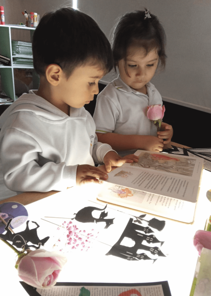 Niños realizando actividad de lectura y exploración creativa en Kids Town